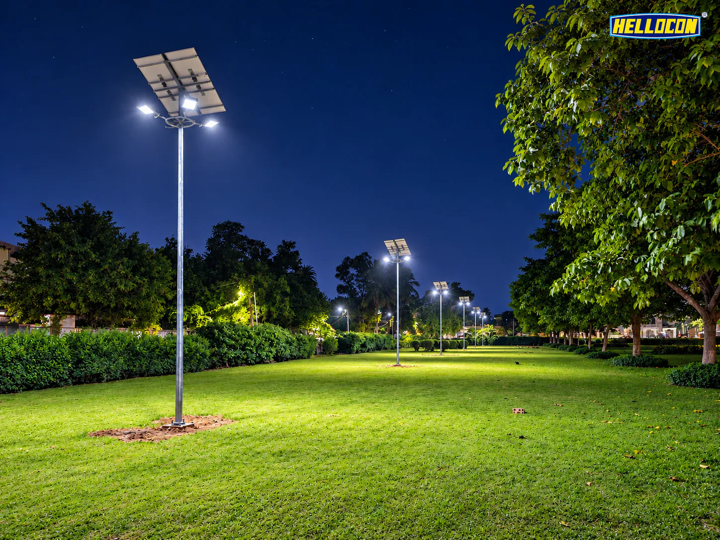 Row of solar mini masts with pole-top panels and LED floodlights lighting a long park lawn at night